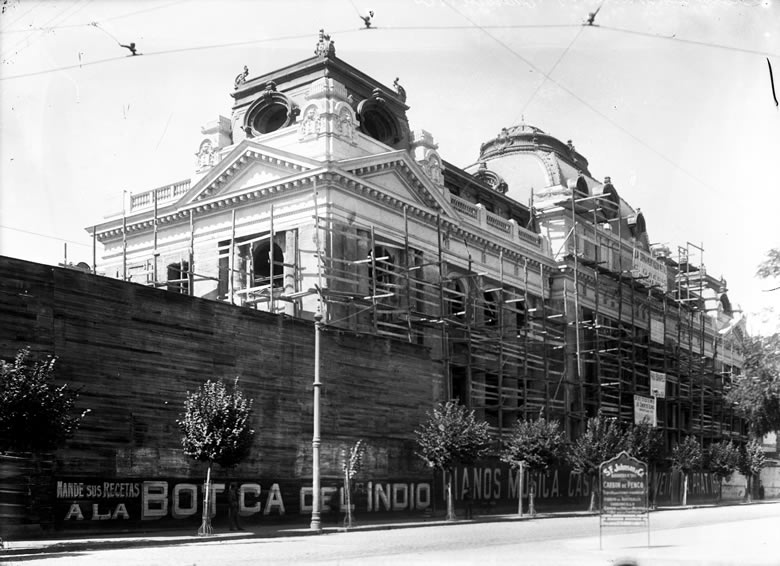 La Biblioteca Nacional se construyó en los terrenos del Monasterio Santa Clara. Durante su edificación se puso publicidad en los muros de madera que la rodeaban. Fuente: Archivo Fotográfico Biblioteca Nacional